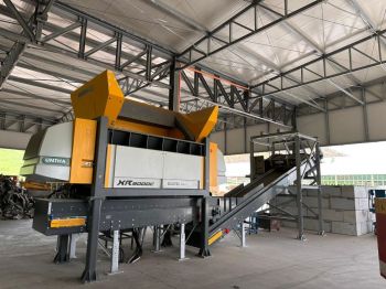 Impianto di triturazione UNTHA XR3000 C dotato di nastri, deferrizzatore e impianto di nebulizzazione.